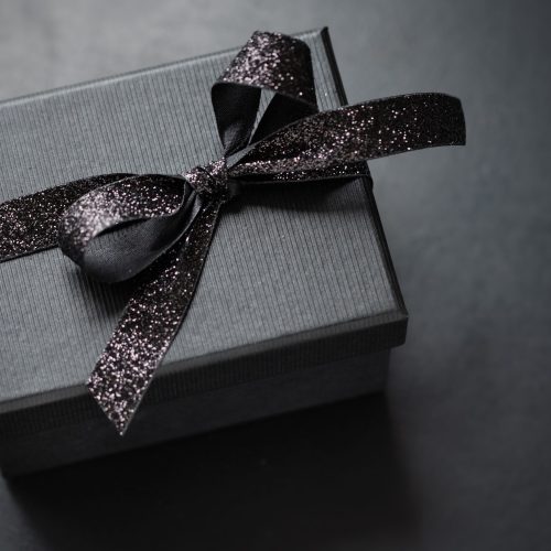dark black giftbox with black ribbon dark background closeup scaled